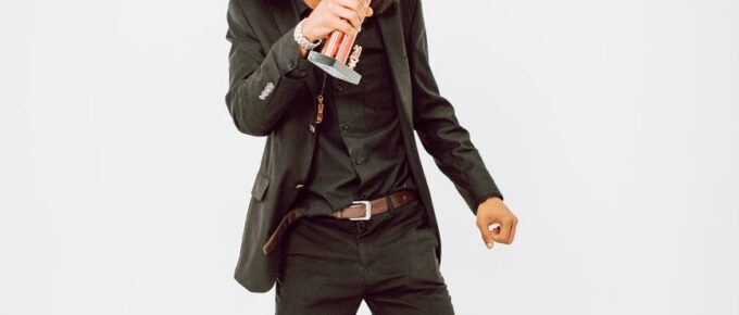 man in black suit dancing with a trophy on hand